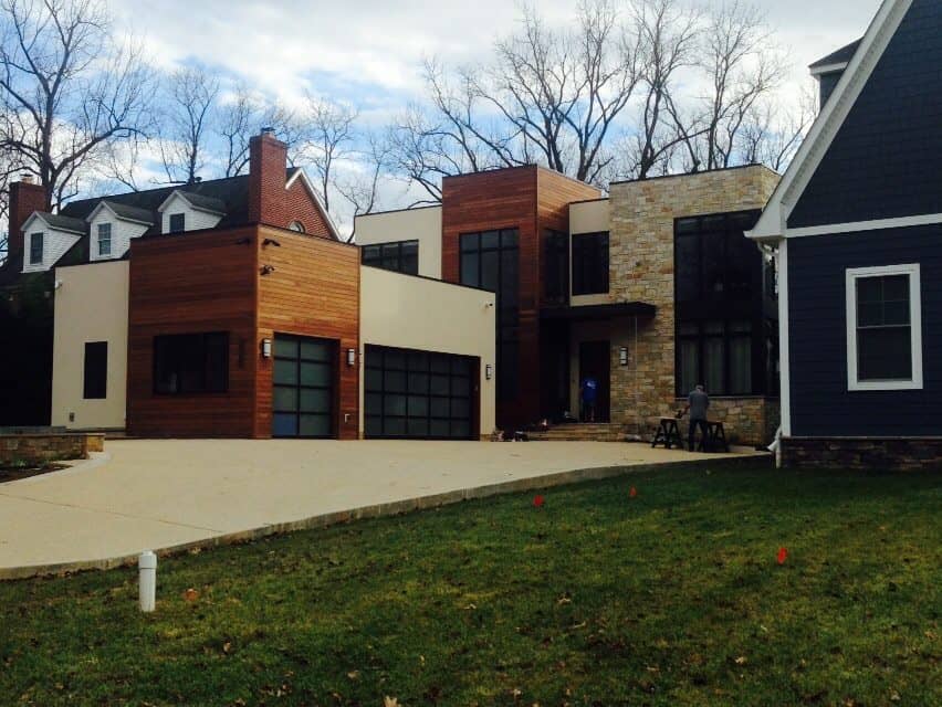 A large house with two garage doors and a driveway.