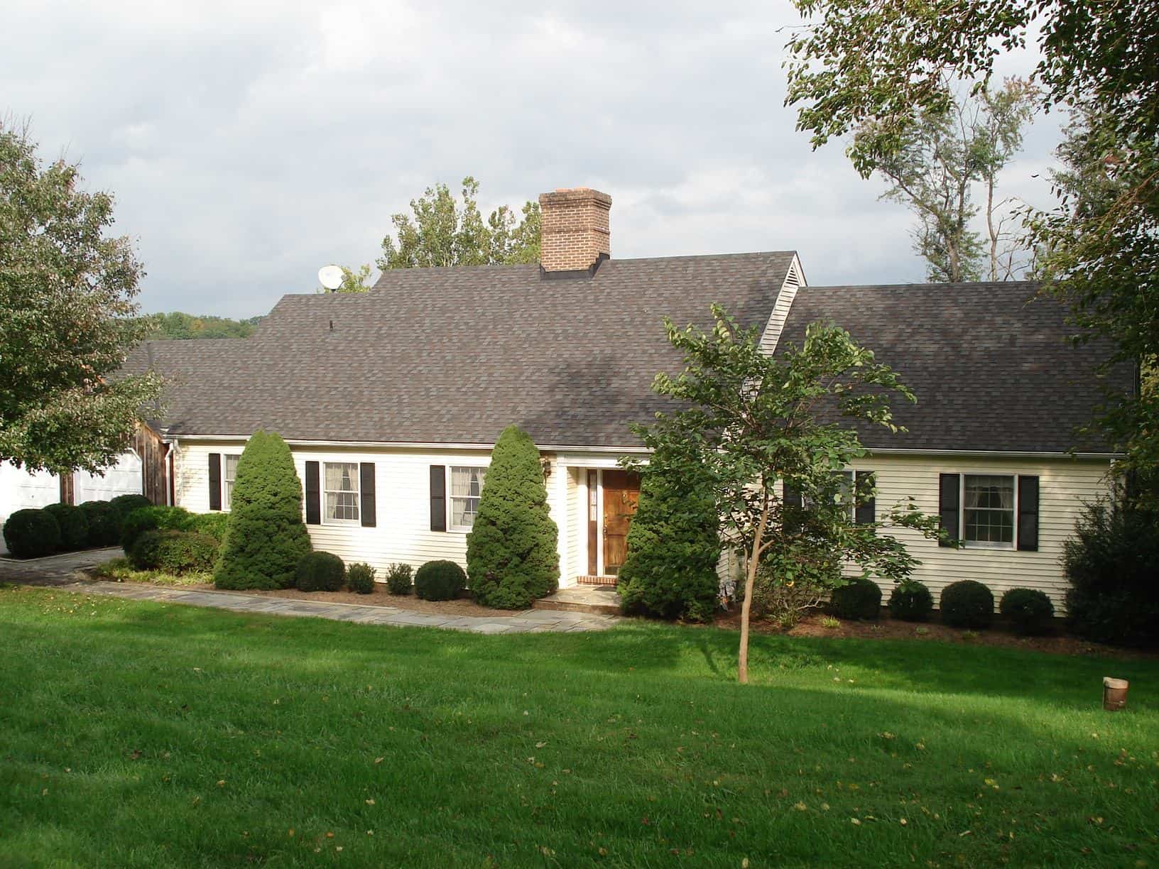 A white house with a large lawn in front of it.