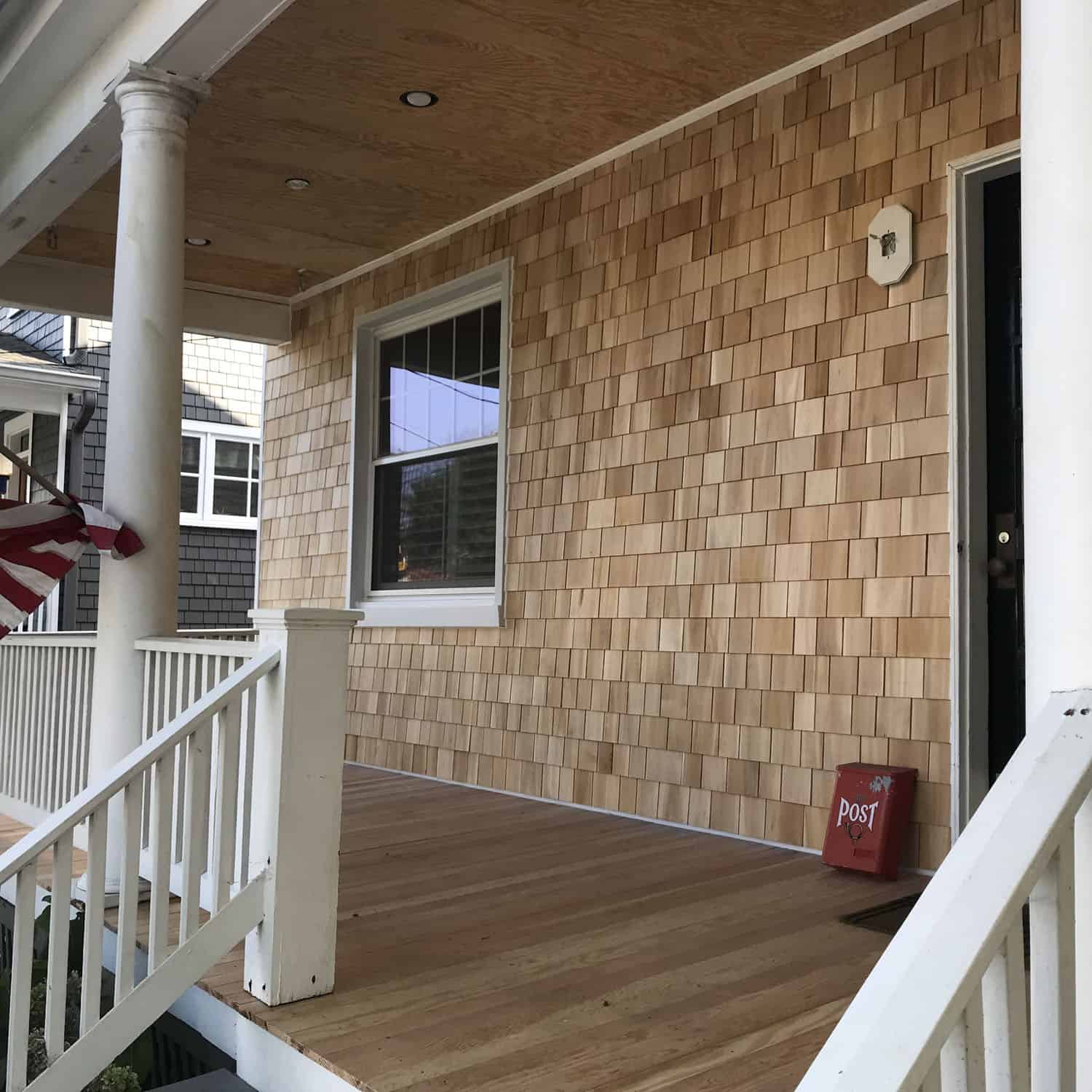 A porch with wooden floors and white railings.